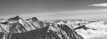 Black and white panorama of snowy mountains in clouds at nice winter evening. Caucasus Mountains, Georgia, region Gudauri.の写真素材