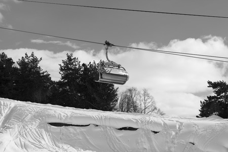 Chair-lift and snowy off-piste slope with traces from skis and snowboards in ski resort. Caucasus Mountains at winter. Tetnuldi, Svaneti region of Georgia. Black and white toned landscape.の写真素材