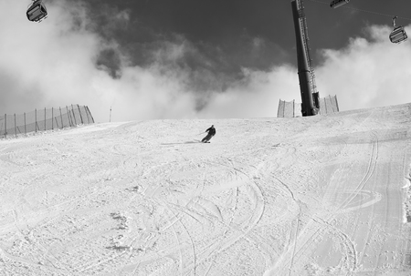 Skier downhill on snowy ski slope at sun winter day. Caucasus Mountains, Shahdagh, Azerbaijan. Black and white toned image.の写真素材