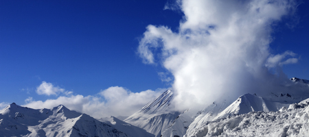 Panoramic view on snowy mountains and beautiful blue sky with clouds. Caucasus Mountains, Georgia, region Gudauri at winter.の写真素材
