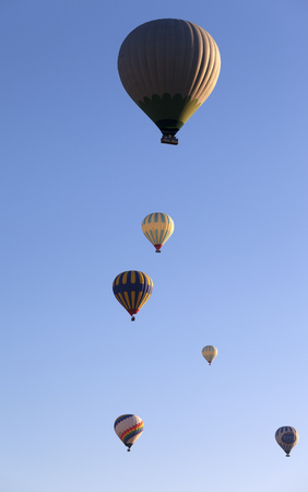 GOREME, CAPPADOCIA, TURKEY - MAY, 2013: Hot air balloons on blue clear sunlit sky at early sunny morningのeditorial素材