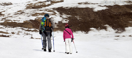 Panoramic view on father and daughter with ski poles on snowy slope in little snow year. Caucasus Mountains, Georgia, region Gudauri.の写真素材