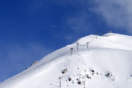 Snowy off-piste ski slope and ropeway at winter morning. Caucasus Mountains. Georgia, region Gudauri, Mount Sadzele.の写真素材