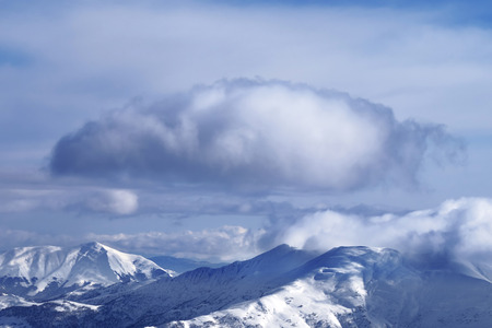 Snowy sunlit mountains and sky with clouds at winter evening. Caucasus Mountains, Georgia, region Gudauri.の写真素材
