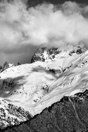 Black and white view on snowy mountains in clouds in winter sun day. Mount Ushba, Caucasus Mountains. Svaneti region of Georgia.の写真素材