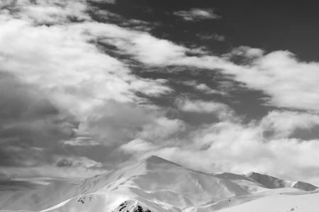 Black and white snowy mountains and sky with clouds in winter evening. Caucasus Mountains, Svaneti region of Georgia.の写真素材