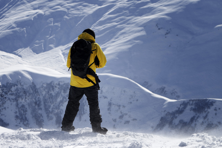 Snowboarder on top of snowy off-piste slope before descent at windy winter day. Caucasus Mountains, Georgia, region Gudauri.の写真素材