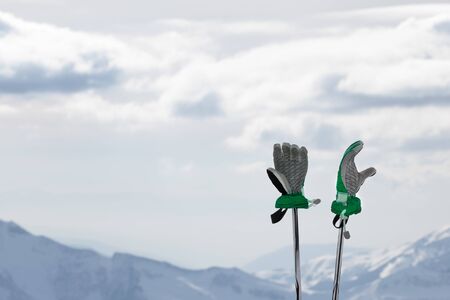 Gloves on ski poles and snowy winter mountains in background. Caucasus Mountains. Georgia, region Gudauri.の写真素材