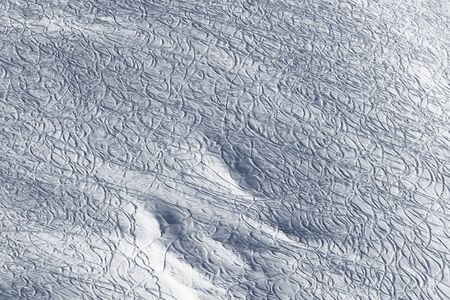 Snowy off piste slope for freeride with traces from skis and snowboards at sun winter morningの写真素材