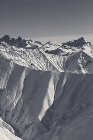Snowy mountains in nice sun evening. Caucasus Mountains, Georgia, region Gudauri at winter. Black and white retro toned landscape.の写真素材