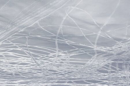 Snowy off piste slope with traces of skis and snowboards at sunny winter dayの写真素材
