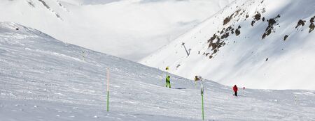Skier and snowboarder downhill on freeride trace and snowy mountains at sun cold day. Caucasus...