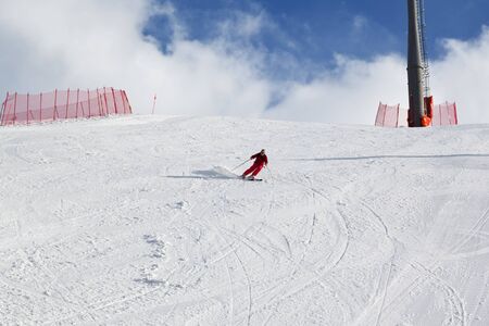 Skier descends on snowy sunlight ski slope at sunny winter day. Greater Caucasus Mountains, Shahdagh, Azerbaijan.の写真素材