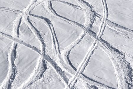 Off-piste snowy ski slope with trace from skis and snowboards at sun winter dayの写真素材
