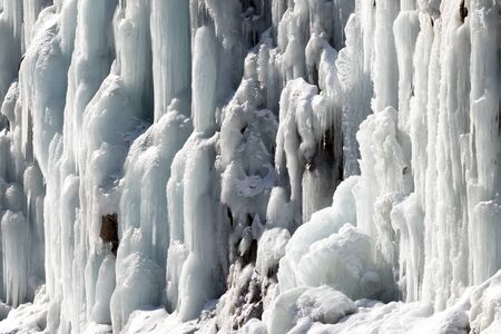 Icy mountain waterfall at winter sunny day. Close-up view.の写真素材