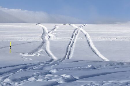 Off-piste ski slope with new-fallen snow and traces from skis, snowboards after snowfall. Caucasus Mountains in sunny winter evening, Georgia, region Gudauriの写真素材