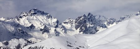 Snowy off-piste slope and mountains in clouds at winter. Caucasus Mountains, Svaneti region of Georgia. Panoramic view.の写真素材