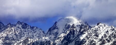 Panoramic view on snowy mountains in clouds at sunny winter day. Caucasus Mountains. Svaneti region of Georgia.の写真素材