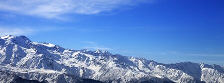 Sunlight snowy mountains and blue sky with clouds in winter day. Caucasus Mountains. Georgia, region Svanetia. Panoramic view.の写真素材