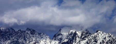 High snowy mountains in clouds at sunny winter day. Caucasus Mountains. Georgia, region Svaneti. Panoramic view.の写真素材