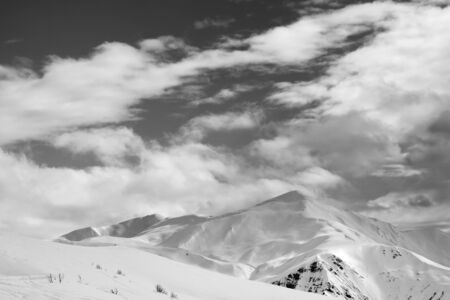 Black and white snowy ski slope and sky with clouds in winter evening. Tetnuldi, Caucasus Mountains, Svaneti region of Georgia. 

の写真素材