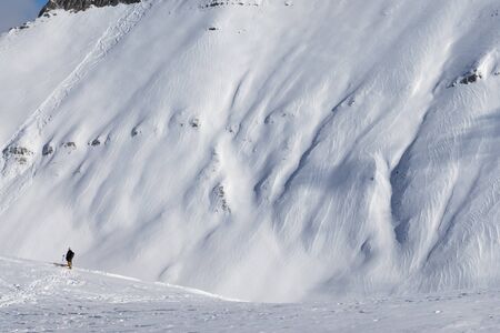 Skiers and off-piste slope with traces of skis, snowboards and avalanches. Caucasus Mountains at sun winter day, Georgia, region Gudauri.の写真素材