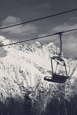 Ski-lift on ski resort and snowy mountains at sunny winter day. Caucasus Mountains. Hatsvali, Svaneti region of Georgia. Black and white retro toned landscape.の写真素材