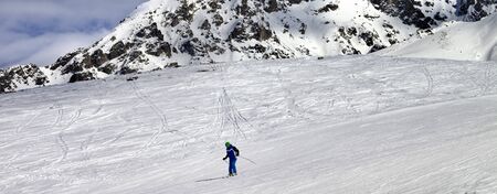 Skier on snowy ski slope at sun winter day. Caucasus Mountains. Tetnuldi, Caucasus Mountains, Svaneti region of Georgia. Panoramic view.の写真素材