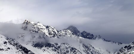 Panoramic view on sunlit snowy mountains and gray cloudy sky. Caucasus Mountains at winter. Georgia, region Svanetia.の写真素材