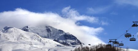 Panoramic view on ski-lift, snowy off-piste slope and mountain in clouds. Caucasus Mountains at winter. Mount Tetnuldi, Svaneti region of Georgia.の写真素材