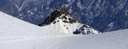Trace from ski and snowboards on snowy off-piste slope. Caucasus Mountains at winter, Georgia, region Gudauri. Panoramic view.の写真素材