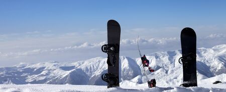 Three snowboards in snow near off-piste slope in sun winter day. Caucasus Mountains, Georgia, region Gudauri. Panoramic view.の写真素材