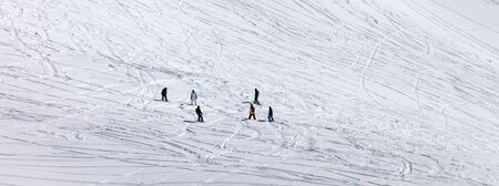 Snowboarders and skiers on snowy off piste slope at winter. Panoramic view.の写真素材