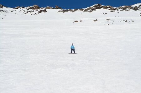 Snowboarder on off-piste ski slope in high snowy mountains at sun winter day. Caucasus Mountains, region Dombay.の写真素材