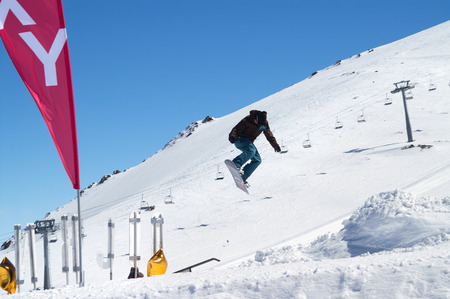 DOMBAY, RUSSIA â€“ APRIL, 2010: â€œFlammable Camp Dombai 2010â€. Snowboarder jumping...