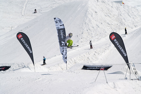 DOMBAY, RUSSIA â APRIL, 2010: âFlammable Camp Dombai 2010â. Skier jumping in snow park at ski resort on sun winter day. Caucasus Mountains, region Dombay.のeditorial素材