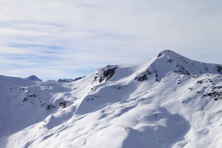 Snowy off piste ski slope at high winter mountains and sunlit cloudy sky. Italian Alps. Livigno, region of Lombardy, Italy, Europe.の写真素材