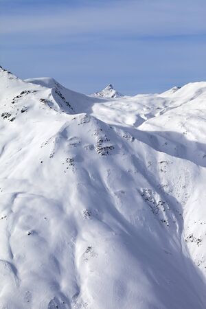 Snowy off-piste ski slope, sunlit plateau and peak at high winter mountains. Italian Alps. Livigno, region of Lombardy, Italy, Europe.の写真素材