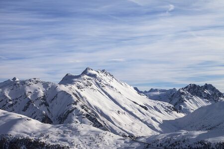 Snowy high winter mountains and beautiful cloudy sunlit sky. Italian Alps. Livigno, region of Lombardy, Italy, Europe.の写真素材