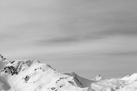 High mountains with snowy peak and sunlit cloudy sky at winter morning. Italian Alps. Livigno, region of Lombardy, Italy, Europe. Black and white toned landscape.の写真素材