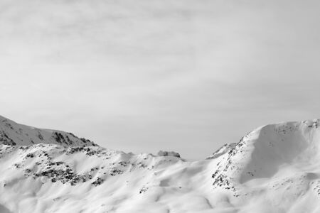 High winter mountains with snowy slopes and sunlit cloudy sky. Italian Alps. Livigno, region of Lombardy, Italy, Europe. Black and white toned landscape.

の写真素材