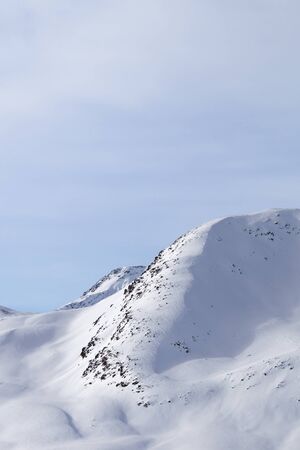 High winter mountains with snowy slopes and sunlit cloudy sky at morning. Italian Alps. Livigno, region of Lombardy, Italy, Europe.の写真素材