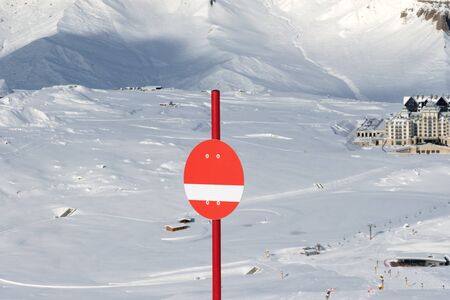Sunlit red marker on snowy ski slope in high winter mountains. Caucasus Mountains, Shahdagh, Azerbaijan.の写真素材