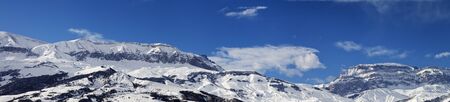 Large panorama of high snowy mountains and blue sky with clouds at sun winter day. Caucasus Mountains, Shahdagh, Azerbaijan.の写真素材