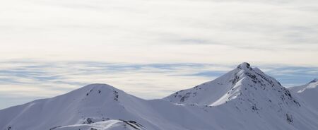 High winter mountains with snowy slopes and sunlit cloudy sky at morning. Italian Alps. Livigno, region of Lombardy, Italy, Europe. Panoramic view.

の写真素材