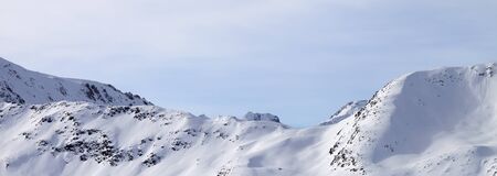 High winter mountains with snowy slopes and sunlit cloudy sky at morning. Italian Alps. Livigno, region of Lombardy, Italy, Europe. Panoramic view.の写真素材