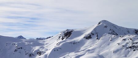 Snowy off piste ski slope at high winter mountains and sunlit cloudy sky. Italian Alps. Livigno, region of Lombardy, Italy, Europe. Panoramic view.の写真素材