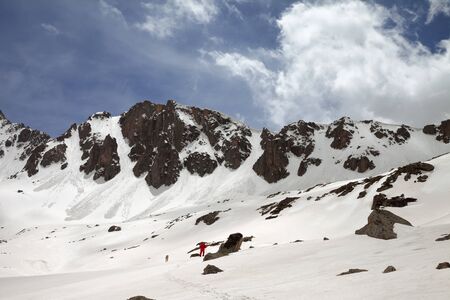 Silhouette of hiker in red and dog on snowy plateau in high mountain at sunny day. Turkey, Kachkar Mountains, highest part of Pontic Mountains. の写真素材