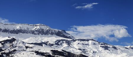 Panorama of high snowy mountains and blue sky with clouds at sunny winter day. Caucasus Mountains, Shahdagh, Azerbaijan.の写真素材