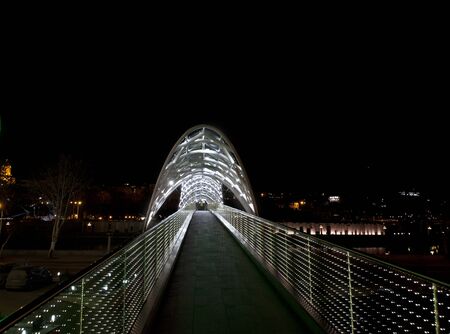View on bridge of Peace over Kura River (Mtkvari) with neon illuminated at night. Tbilisi, Georgia.の写真素材